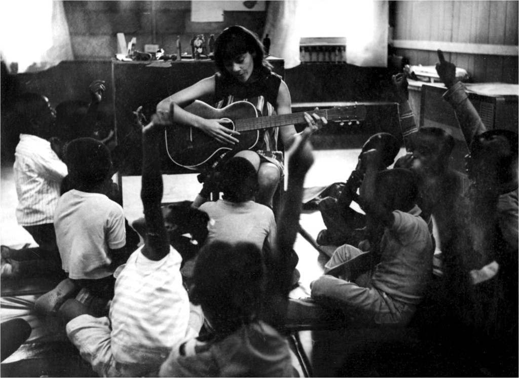 teaching strategies founder diane trister dodge playing guitar while preschool children engage and listen